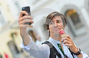 Selfie of handsome young man eating ice cream