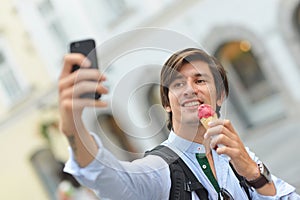 Selfie of handsome young man eating ice cream