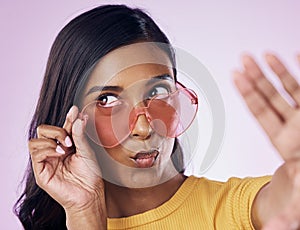 Selfie, heart and sunglasses by indian woman in studio emoji, cool and fun on purple background. Glasses, trendy and