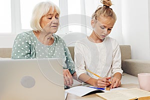 Selfie hugging smiling video education granddaughter togetherness sofa family bonding laptop call child grandmother