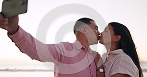 Selfie, kiss and couple at the beach for travel, romance and vacation with love in nature together. Kissing, photo and
