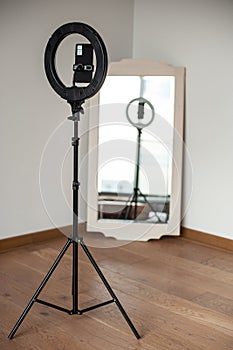 Selfie LED ring light with smartphone. Blogging equipment. Studio background.