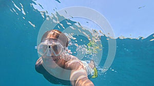 SELFIE: Man enjoys his vacation by snorkeling around the crystal clear ocean.