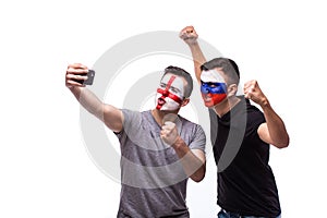 Selfie on phone of Englishman and Russian football fans in game supporting of national teams on white background.