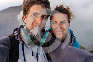 Selfie photo of adventure seekers with  beautiful mountain  landscape and blue lake with smoke