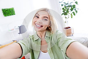 Selfie photo of toothy beaming smiling pretty business woman satisfied enjoying her new interior in modern apartment