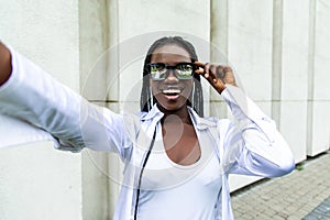 Selfie portrait of laughing black woman outside
