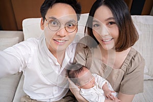 Selfie shot of lovely asian family with baby daughter. group shot of happy father, mother, infant. togetherness concept.