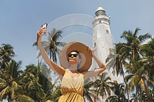 Selfie on Smartphone of Woman Traveler in Front of Famous Landmark of Sri Lanka Country of Dondra Lighthouse