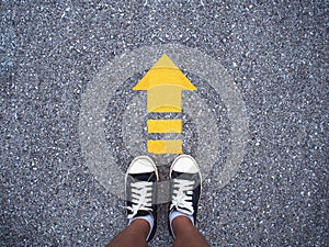 Selfie sneaker black shoes on concrete road with yellow arrow li