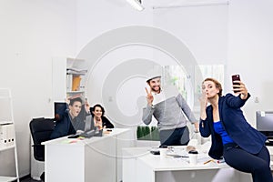 Selfie time. Office workers taking selfies at work