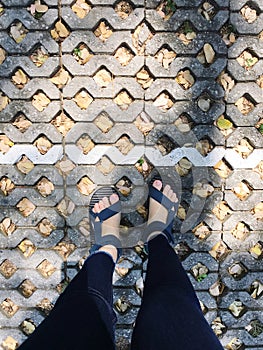 Selfie of woman feet wearing blue slippers on stone walkway