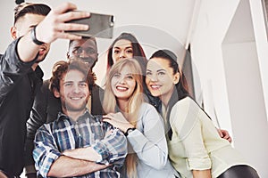 Selfie of young smiling teenagers having fun together. Best friends taking selfie outdoors with backlighting. Happy