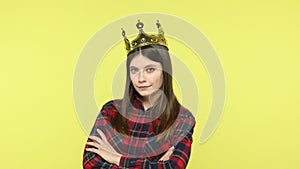 Selfish brunette woman putting on golden crown, feeling confidence, egoism