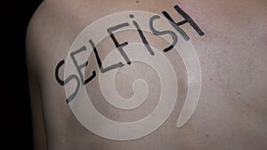 Selfish written on female body closeup, bullying victim suffering pressure