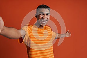 Selfportrait of young handsome smiling happy african man in t-shirt