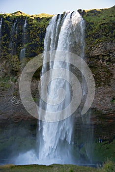 Seljalandsfoss gorge, in Iceland. Incidental people behind the water