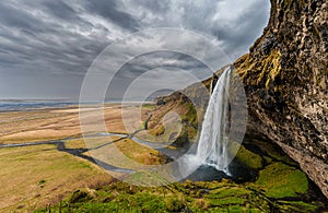 Seljalandsfoss Waterfall in Iceland. One of the ost Famous Waterfall in Iceland. Cloudy Sky. Wide Angle.