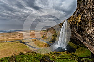 Seljalandsfoss Waterfall in Iceland. One of the ost Famous Waterfall in Iceland. Cloudy Sky. Wide Angle.