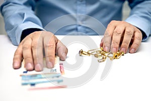 Sell gold jewellry, pawnbroker with euro banknots in the hand photo