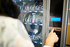 Woman pushing button on vending machine photo