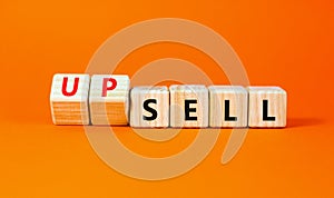 Sell or upsell symbol. Concept word Sell Upsell on wooden cubes. Beautiful orange table orange background. Business Sell or Upsell