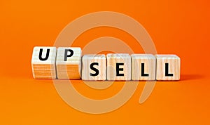 Sell or upsell symbol. Concept word Sell Upsell on wooden cubes. Beautiful orange table orange background. Business Sell or Upsell