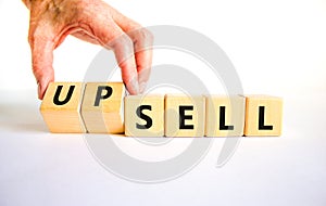Sell or upsell symbol. Concept word Sell Upsell on wooden cubes. Businessman hand. Beautiful white table white background.