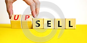 Sell or upsell symbol. Concept word Sell Upsell on wooden cubes. Businessman hand. Beautiful yellow table white background.
