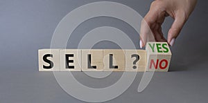 Sell Yes or No symbol. Businessman Hand turns cubes and changes words Sell No to Sell Yes. Beautiful grey background. Business and