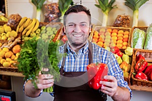 Seller in apron showing fresh vegetables