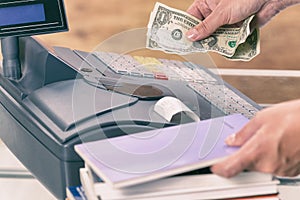 Seller at bookstore using cash register