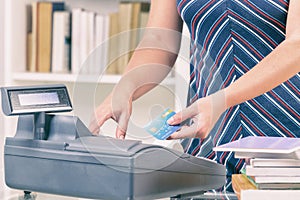 Seller at bookstore using cash register