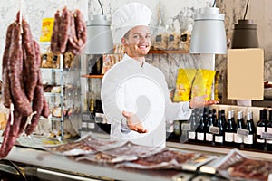 Seller in his grocery shop welcoming customers