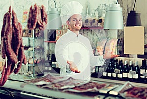 Seller in his grocery shop welcoming customers