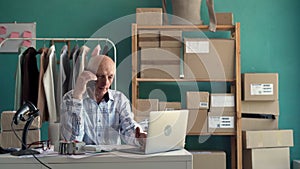 seller old man work on laptop and calling to customer at home office in SME online store