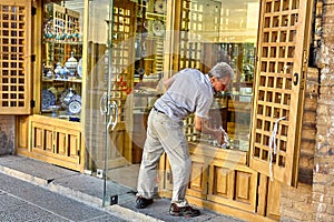 Seller of porcelain washes the shop window, Isfahan, Iran.