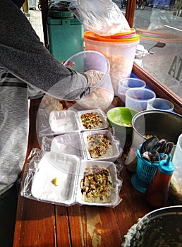 A seller preparing porridges for some customer. Location : Pasar Prambanan Street, 5 December 2021, 07.30 am