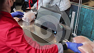 the seller scans the goods at the checkout in the supermarket. close up of female hands scanning barcode of meat