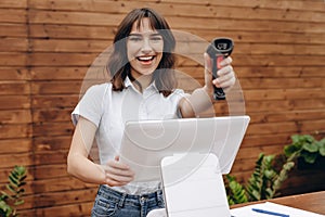 Seller smiling and holding barcode scanner in a hand