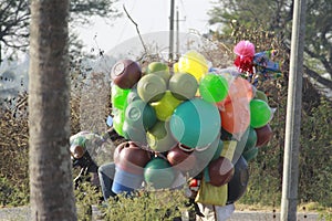 A seller in the village carrying pots of plastic and other vessels on a bicycle. This man  running his life honestly and hardly photo