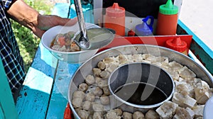 Selling bakso by walking and pushing down the food carts