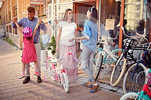 Selling bicycle - Family with happy kid having fun outdoor shopping new bicycle and helmets