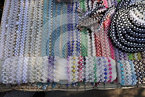 Selling bracelets and beads made of multi-colored glass beads at a city fair
