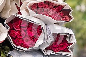 Selling flowers - A bouquet of red / pink roses wrapped in paper