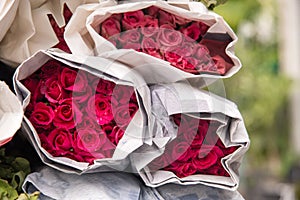 Selling flowers - A bouquet of red / pink roses wrapped in paper