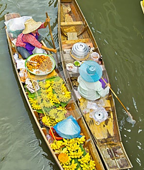 Selling food on a boat at floating market, Thailand