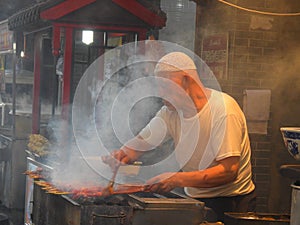 Selling meat skewers in busy night street market. Xi& x27;An China.