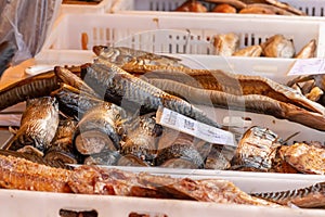 Selling various smoked fish in a street food market