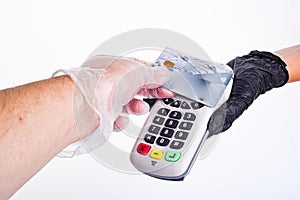 The sells submits a payment terminal. The buyer pays by card. Hands with gloves. Seller`s hand in a glove. Buyer`s hand in a glove